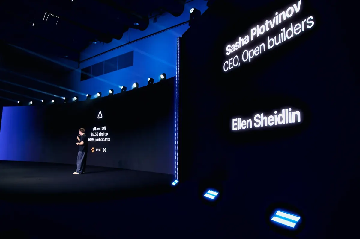 Speaker presenting on stage beside large screens at a business event in Dubai Speaker presenting on stage beside large screens at a business event in Dubai